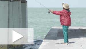 A photo of Barbara Holmes fishing off a dock.