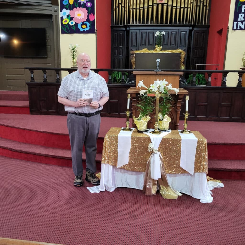 Arthur standing at a church altar holding the book.