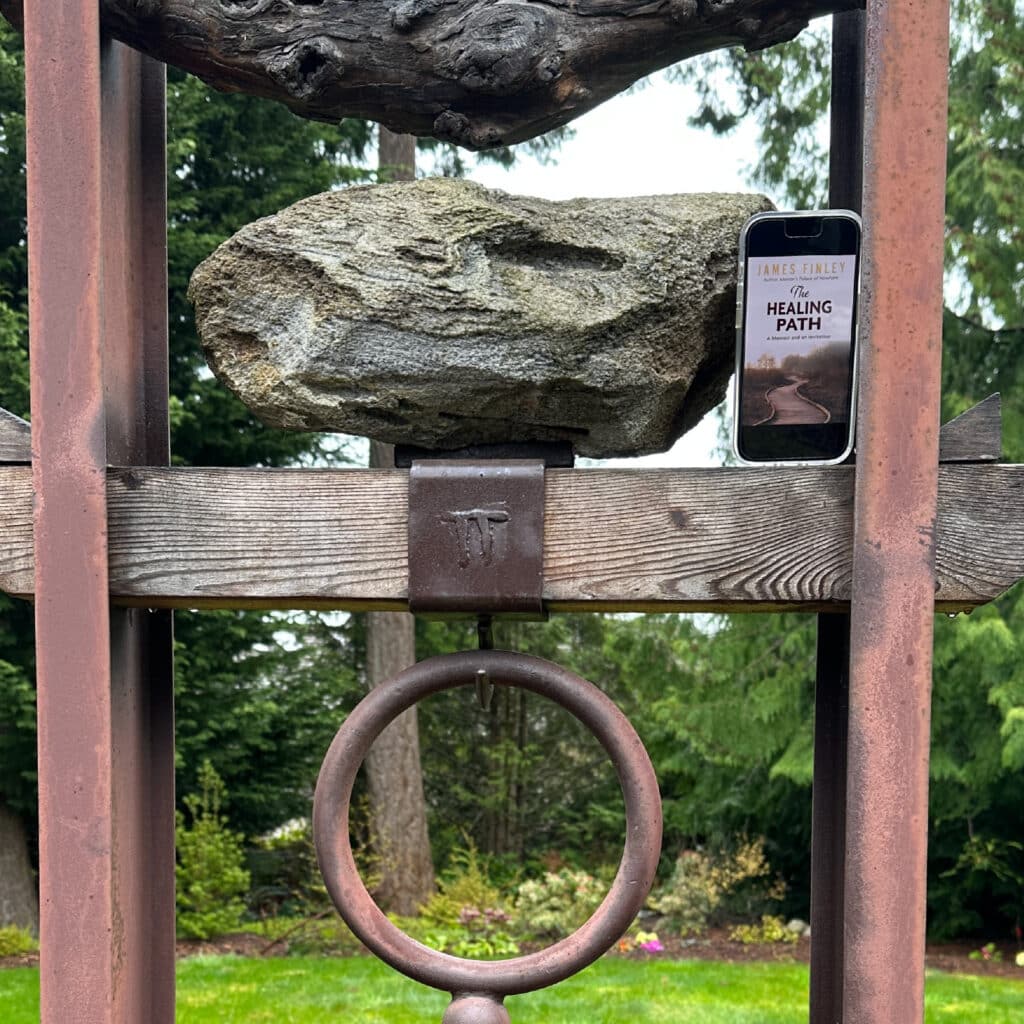The image of the book on a phone next to a prayer bell.