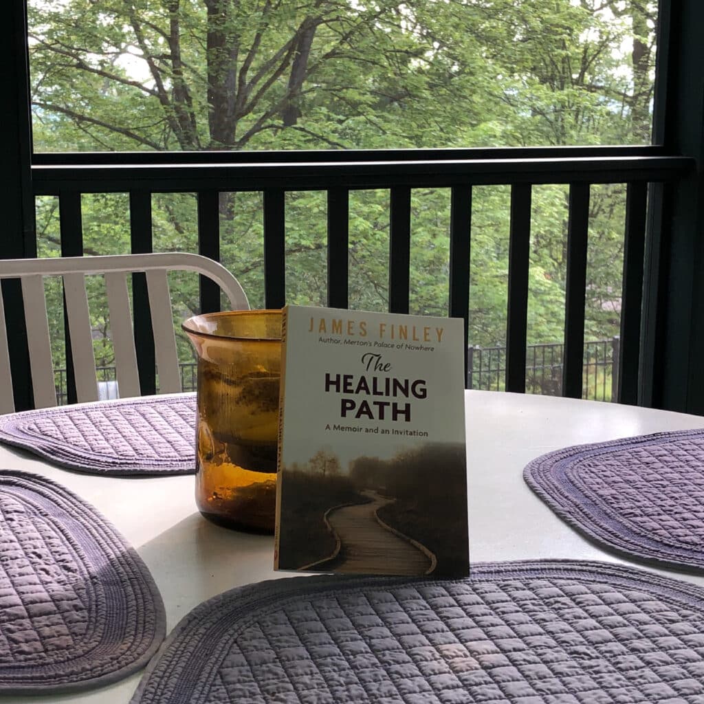 The Healing Path book on a table in front of a window with trees.