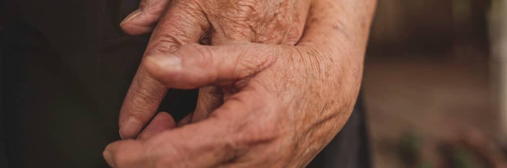 A photo of two aged hands intertwined.