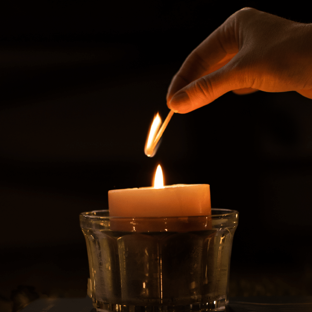 Photo of a hand lighting a candle