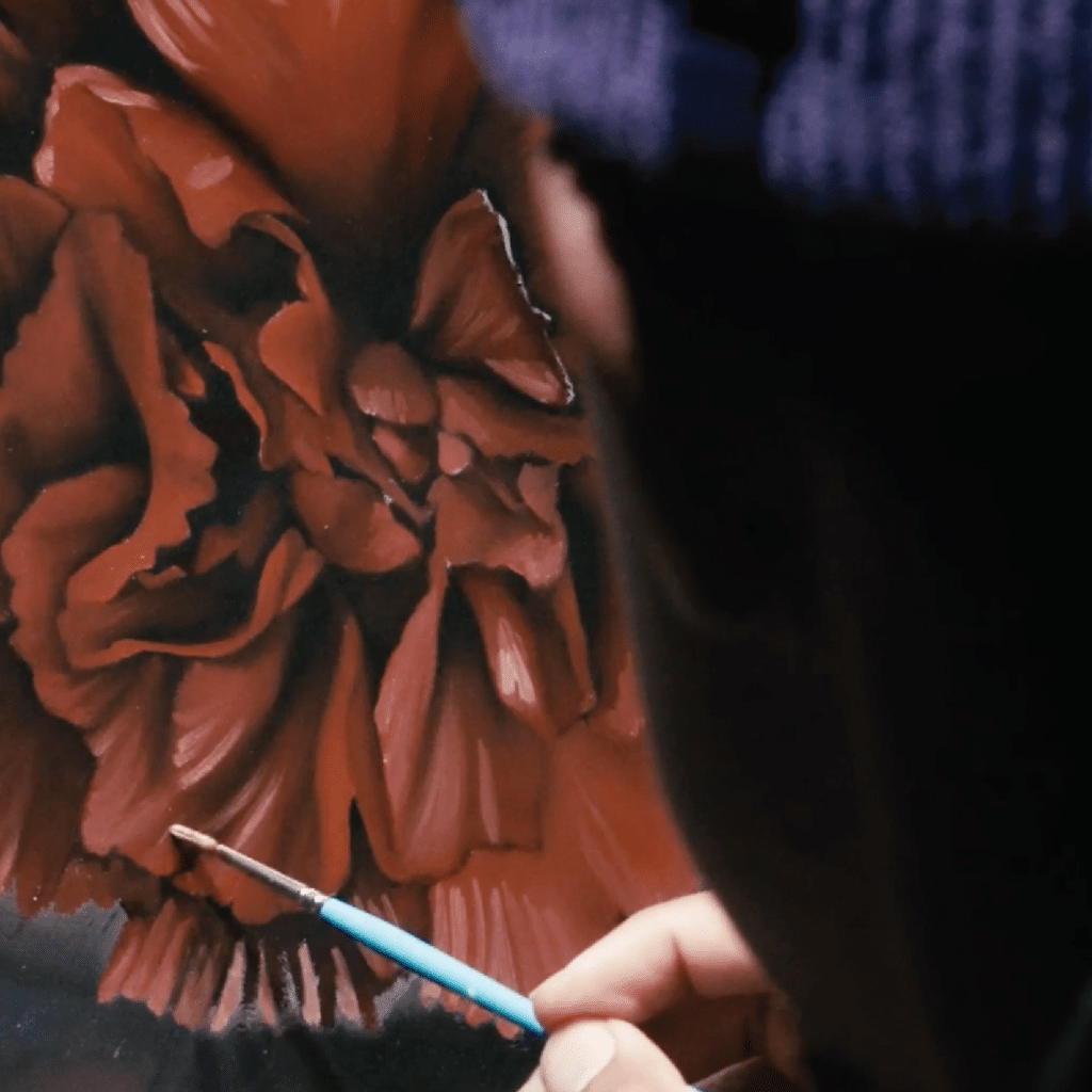 A photo of a painter painting a red flower for the event, "What Do I Do with My Anger?" from the CAC