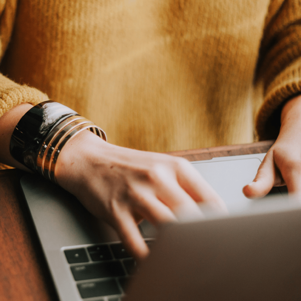 A photo of hands typing on a keyboard.