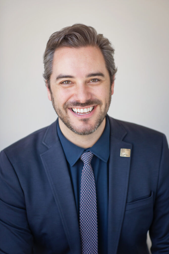 Image of Hunter Mobley smiling in a blue suit jacket