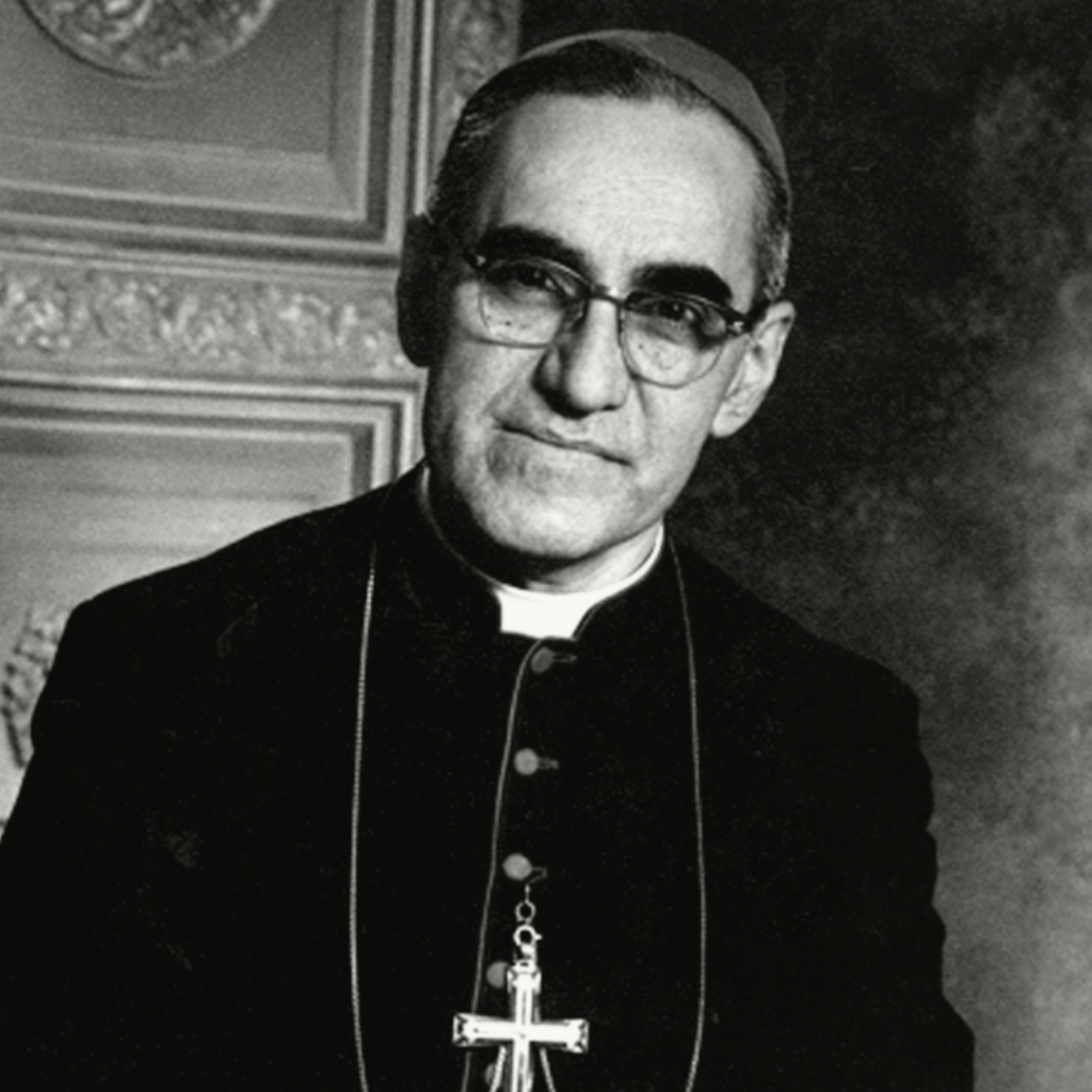 Black and white portrait of Óscar Romero wearing glasses and a clerical collar, exuding a dignified presence.