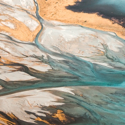An aerial photo of a river meeting a lake.